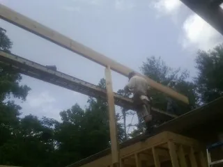 Carpenter setting a ridge beam over a new addition frame — Ice Dam Removal by Roofing Brothers in Elverson