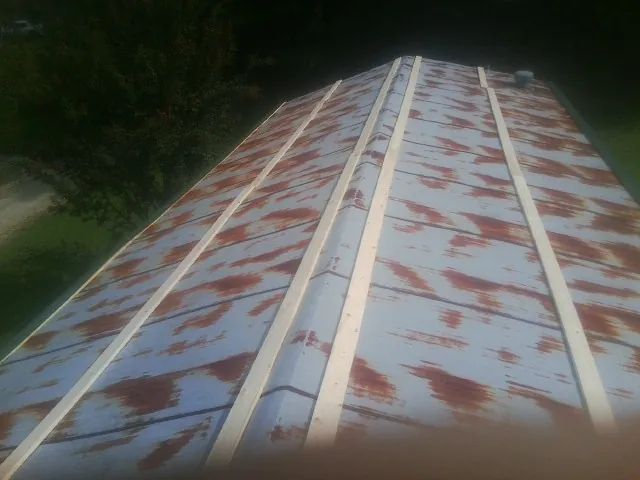 Rusted metal roof panels with new wood purlins before replacement — Storm Damage Roof Repair in Elverson by Roofing Brothers