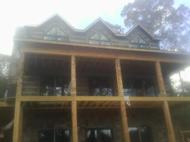 Dormers and porch framing on a large log home under construction — Roof Coating work by our crew in Elverson